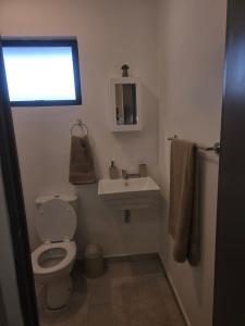 Un baño con inodoro, lavabo y ventana. en 204 The Base Apartment, en Johannesburgo 9 fotos más