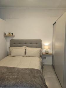 1 dormitorio con 1 cama grande y cabecero gris en 204 The Base Apartment, en Johannesburgo