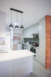 a kitchen with white cabinets and a brick wall at Apartment 70 - 1 On York in George