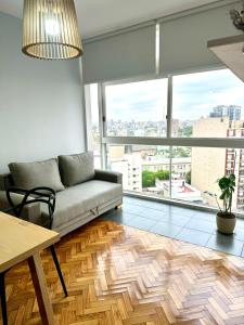 a living room with a couch and a large window at Villa Crespo Movistar Arena in Buenos Aires +18 photos