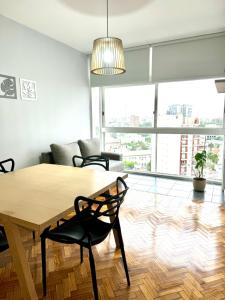 a living room with a wooden table and chairs at Villa Crespo Movistar Arena in Buenos Aires