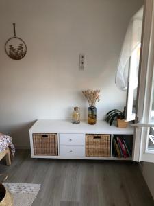 a white cabinet in a living room with a window at gite de saint lye in Saint-Lyé +2 photos