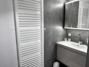 ein Badezimmer mit Waschbecken und Spiegel in der Unterkunft Ferienwohnung Linde in Oberstaufen + 16 Fotos