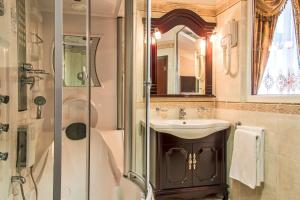 uma casa de banho com um lavatório e um chuveiro em Palace Hotel Polom em Žilina