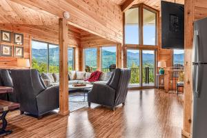 Una sala de estar con un sofá y sillas y ventanas. en Panoramic Views-Fire Pit-Hot Tub-Arcade, en Sevierville