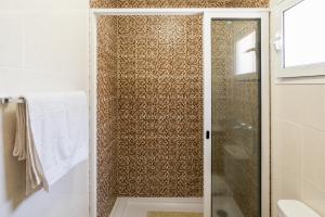 a shower with a glass door in a bathroom at Green Doors - AC and free parking in Machico +19 photos