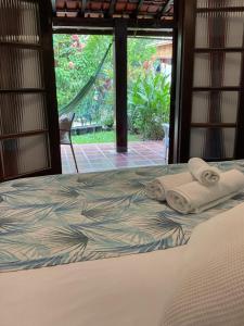 Una cama en una habitación con toallas. en Villa Adria, en Ilhabela 93 fotos más