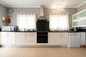 a kitchen with white cabinets and white appliances at Green Doors - AC and free parking in Machico