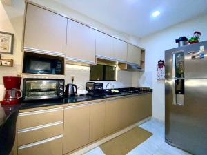 a kitchen with a stainless steel refrigerator and microwave at Apartamento RR Agradable y Moderno c 2 dormitorios y estacionamiento interno techado in Ciudad del Este +16 photos