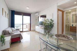 a living room with a couch and a glass table at Blau d´Or Peñiscola in Peniscola