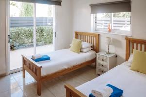 due letti in una stanza con finestra di Sunset Villa private complex heated pool a Ayia Napa Altre 43 foto