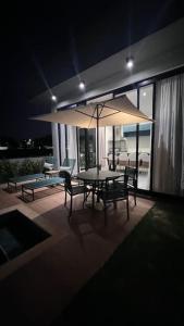 un patio con tavolo, sedie e ombrellone di Natureza, Paz e Conforto a Águas de Santa Barbara