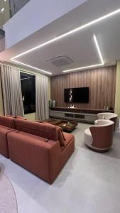 un soggiorno con divano e TV a schermo piatto di Natureza, Paz e Conforto a Águas de Santa Barbara