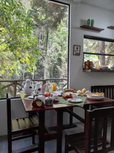 ein Tisch mit Essen darauf in einem Zimmer mit Fenster in der Unterkunft Pousada Tarkna in Teresópolis