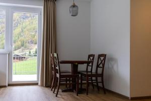 a dining room with a table and chairs and a window at International House Sölden Studio mit Balkon ZW 2 in Sölden