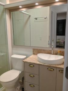 a bathroom with a toilet and a sink and a mirror at Refúgio em Palmas in Governador Celso Ramos