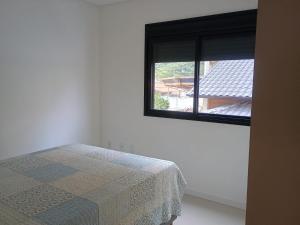 a bedroom with a bed and a window at Refúgio em Palmas in Governador Celso Ramos +28 photos