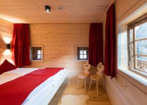 a bedroom with a bed in a room with red curtains at Alfenalm - Ferienwohnungen am Berg - Giatla Haus in Innervillgraten