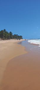 a sandy beach with a group of people in the ocean at Casa da Lua-Taipu de fora-Ba in Taipu +11 photos