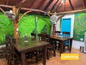a dining room with two tables and a green wall at BTC - Hotel Minca Express Relax - Base Camp in Minca