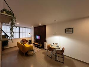 a living room with a yellow chair and a table at Cosy Apartment Queluz By Gt House in Queluz