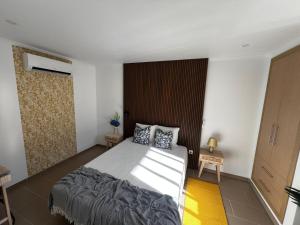 a bedroom with a large bed and a wooden wall at Cosy Apartment Queluz By Gt House in Queluz