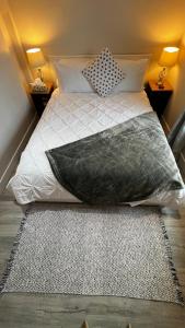 a bed with a pillow and a rug in a bedroom at ALL NEW 2BR Loft in Chilliwack