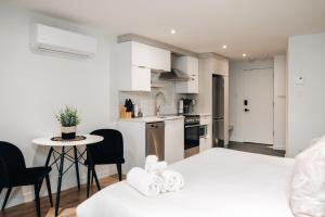 a white kitchen with a small table and chairs at LAÖ Loft Tremblant #106 - KING size Bed in Mont-Tremblant