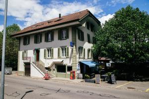 Ein weißes Haus an der Seite einer Straße in der Unterkunft Au Bord Du Lac in Därligen + 16 Fotos
