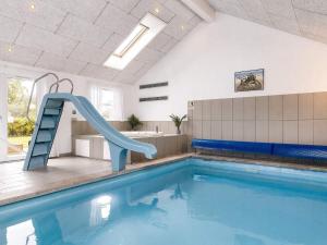a swimming pool with a slide in a building at 5 star holiday home in Idestrup in Marielyst
