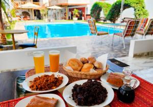 a table with plates of food and two glasses of beer at Hotel Viñas del Sol Eterno in Chincha Alta