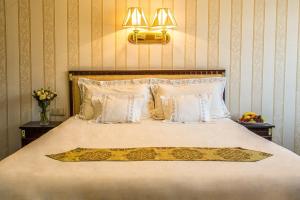 a bedroom with a large bed with white sheets and pillows at Palace Hotel Polom in Žilina