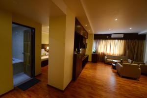 Silver Green Hotel في يانغون: غرفة معيشة بها أريكة وتلفزيون في غرفة