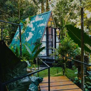 una casetta nella foresta con un tetto blu di The WE2 - Wildwood Elegance Escape a Bentota