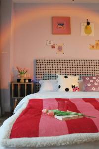 ein Schlafzimmer mit einem Bett mit einer rot-weißen Decke in der Unterkunft suansuan Apartment in Chengdu