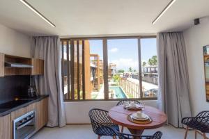 a living room with a table and a large window at Studio vista mar - Milagres - AL in Pôrto de Pedras
