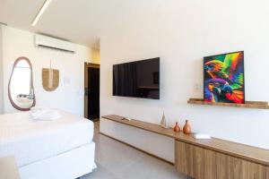 une chambre avec un lit et une télévision sur un mur dans l'établissement Studio vista mar - Milagres - AL, à Porto de Pedras