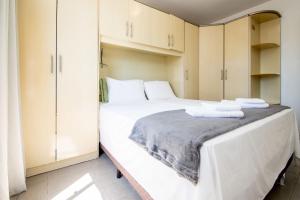 une chambre avec un grand lit blanc et des armoires dans l'établissement Apto no Centro de Balneário Camboriú CR9789, à Balneário Camboriú