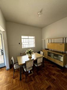 una sala da pranzo con tavolo e sedie di Aconchego da vovó! Casa para 9 pessoas e 2 carros a Belo Horizonte