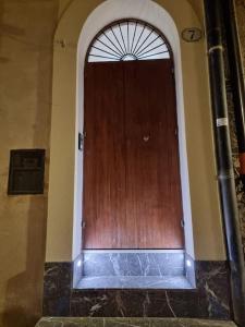 a wooden door in a building with an archway at Domus Deva in Cefalù +4 photos