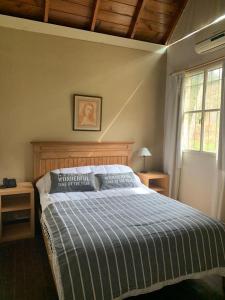 una camera da letto con un letto con un piumone blu di Duplex Mardifiore Pinamar a Pinamar