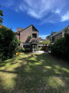 una casa con un ampio giardino con una casa di Duplex Mardifiore Pinamar a Pinamar