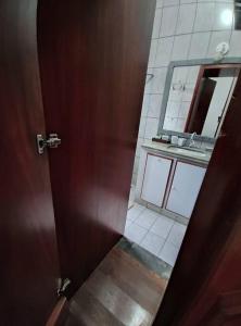 a bathroom door with a mirror and a sink at Casa Nivaldo Ribeiro in Rio Verde +15 photos
