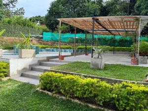 un conjunto de escaleras en un jardín con un pabellón en Villa San Martín, en Sopetrán