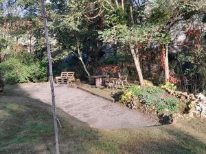 a garden with a table and a bench and trees at Maison avec jardin, piscine chauffée et baignade à proximité - Le Menoux - FR-1-591-234 in Le Menoux