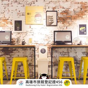 un negozio con sgabelli gialli e un bancone con un computer di Ahiruyah Guesthouse a Kaohsiung
