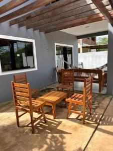 d'une terrasse avec 3 chaises en bois et une table. dans l'établissement Casa Parque do Ribeirão - Casa com piscina, à Lençóis