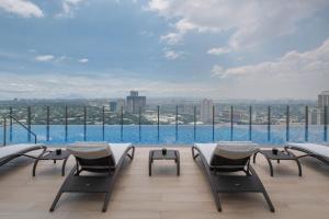 a balcony with chairs and a view of the city at Citadines Benavidez Makati in Manila