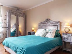 a bedroom with a bed with blue sheets and pillows at Maison de caractère avec piscine chauffée, étang privé et proche forêt, à 90 min de Paris - FR-1-581-48 in La Chapelle-Fortin +28 photos