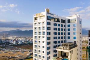 un bâtiment blanc avec une enseigne au sommet dans l'établissement Vesna Hotel Nha Trang, à Nha Trang